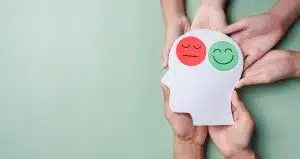 Hands holding sad face and happy smiley face on brain paper cut out, bipolar and depression, mental health concept, personality, mood change, therapy healing split concept